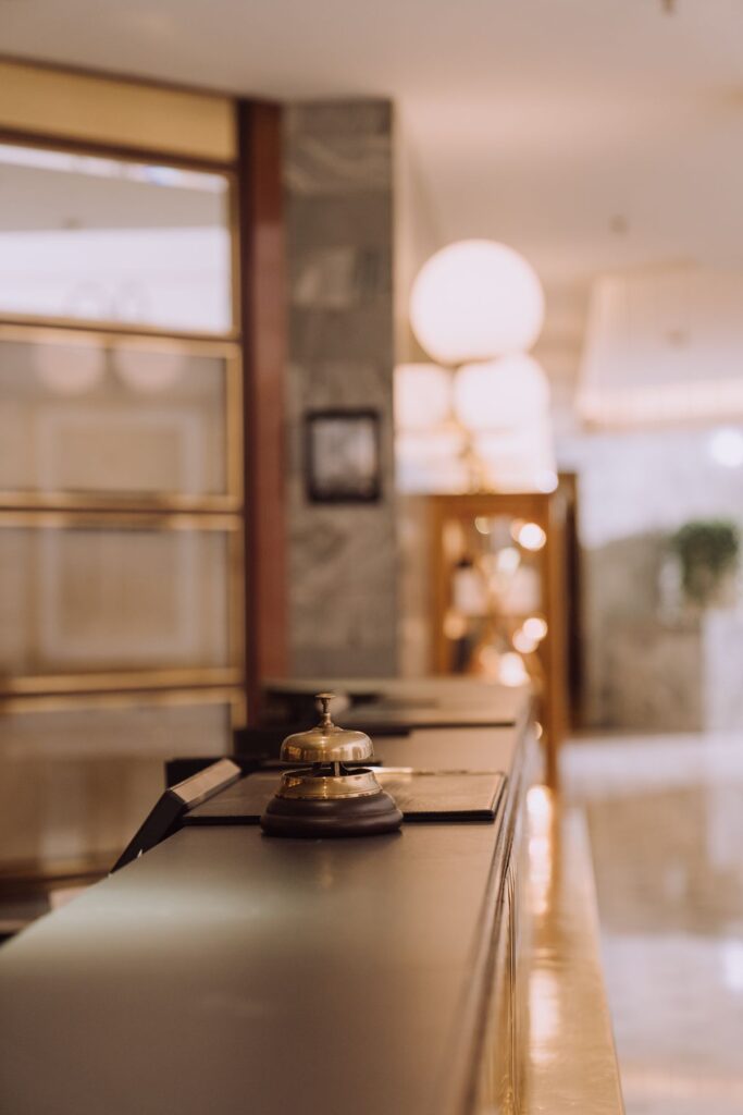 Mostrador de recepción de un hotel con campana y llavero, ambiente de hospitality