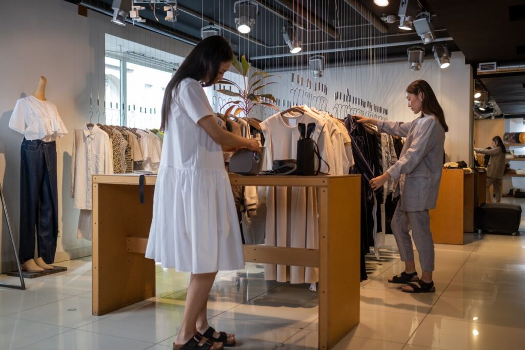 Dos empleadas organizando prendas en el interior de una tienda de retail de moda